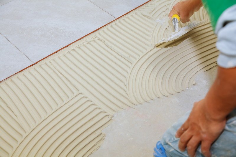 Tile adhesive application showing mortar being spread